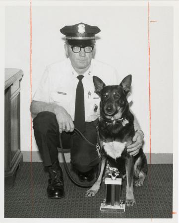 Portrait of Officer Kenneth Brewster and SI Guard-dog "John" with Competition Trophy