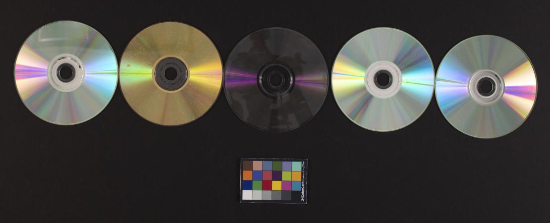 Five CDs and a color card against a black background.