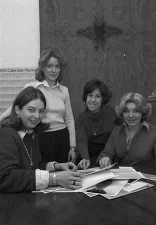 Four women gather around a table on which papers are spread out. Kotkin is the second from the right