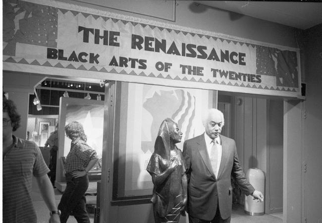 Mercer Ellington, son of Duke Ellington, stands at the entrance of the exhibit "The Renaissance: Bla