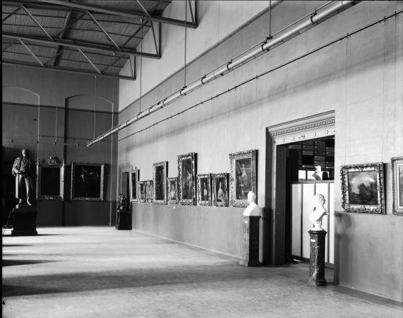 Image of a room and doorway with a lot of art hanging on the walls. 