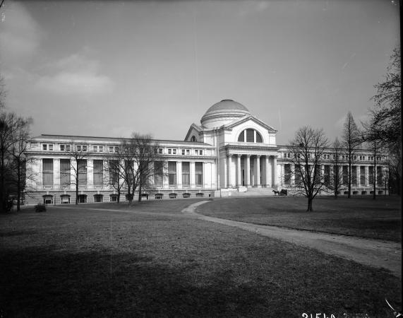 A view of the National Museum of Natural History in 1911. There is a horse and carriage near the ent