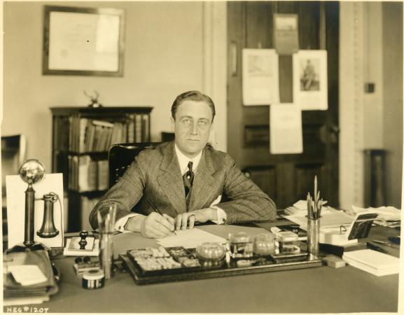 Franklin Delano Roosevelt sitting at his desk in the Executive building.