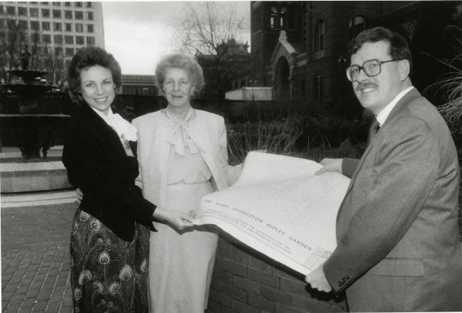 Two women and one man hold up a large piece of paper that reads: "The Mary Livingston Ripley Garden.