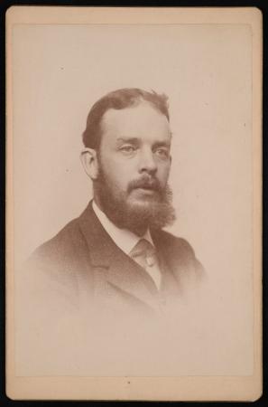 Portrait of a man wearing a suit with a beard.