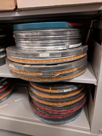 Circular tin cans for film that are stacked on top of one another. Slight rust is visible,